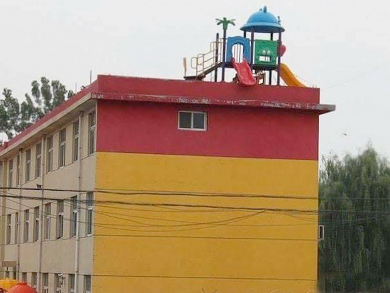 Een plastic speelset geplaatst op de dakrand van een flat.